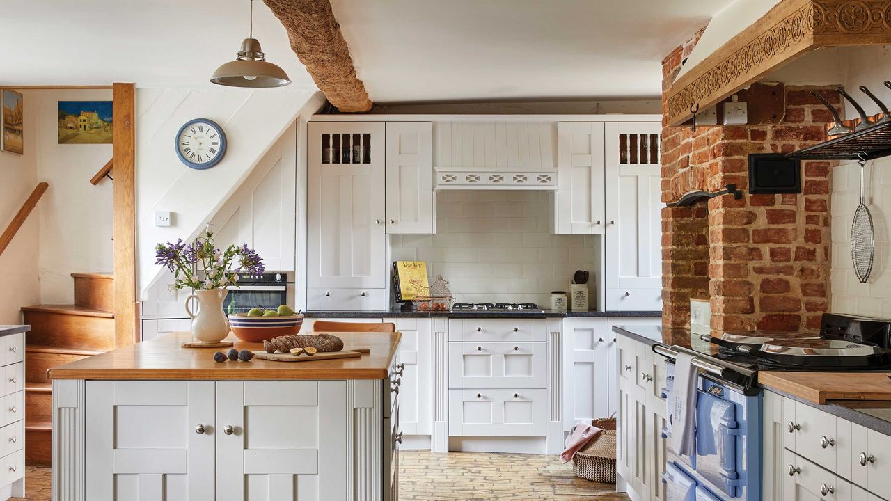 traditional farmhouse kitchen with cream units, stone floor and pale blue range cooker