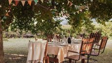 Table in garden set for meal with bunthing overhead