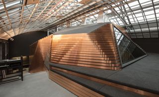 A winding staircase runs through the centre of the space, leading up to a mezzanine lounge perched on top of the recording rooms