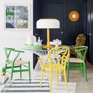 room with round glass table and green and yellow chairs
