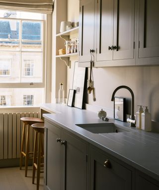 small kitchen with narrower section of worktop at end of room by window