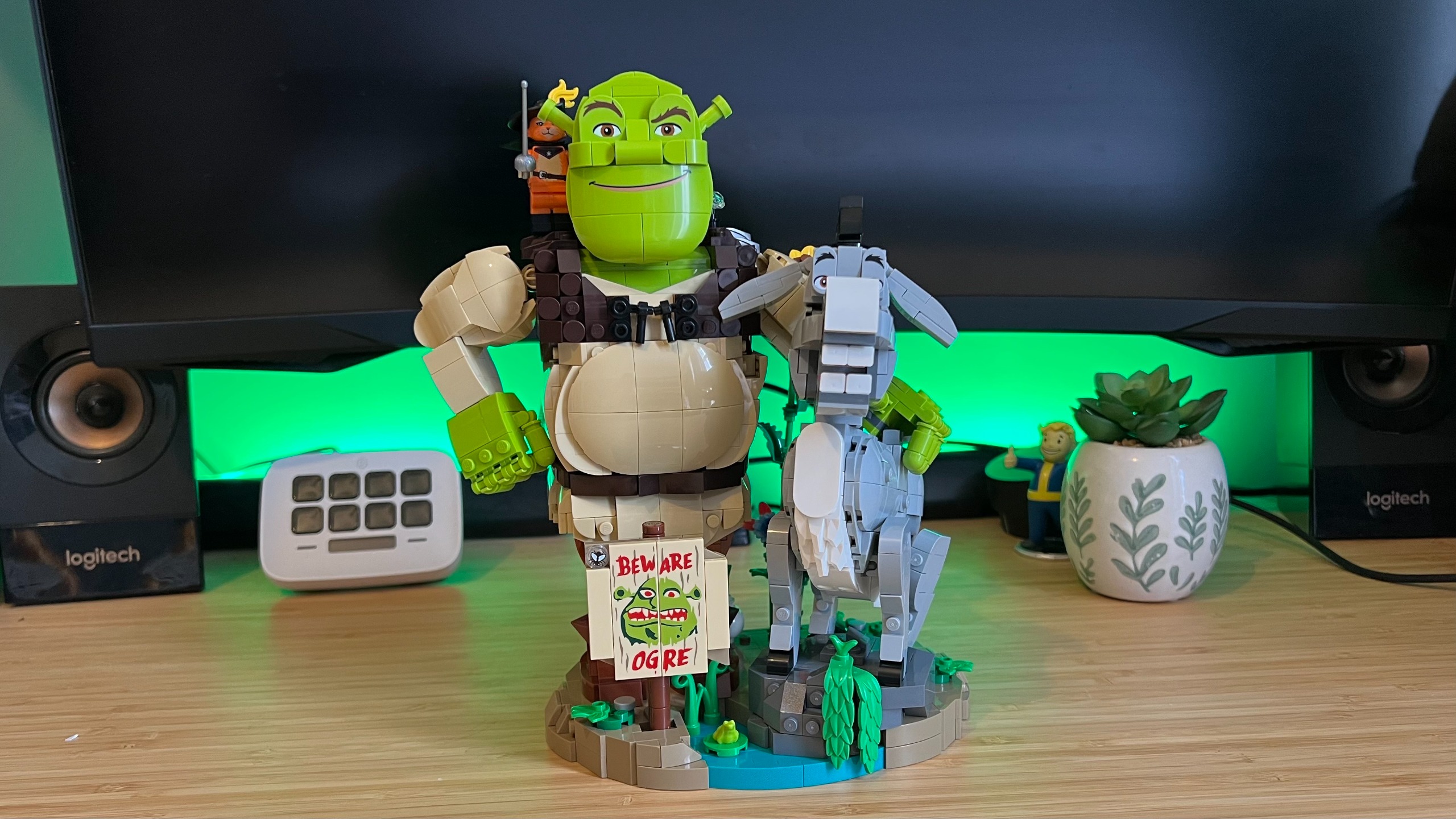 Lego Shrek, Donkey &amp; Puss in Boots set on a wooden desk with green backlighting