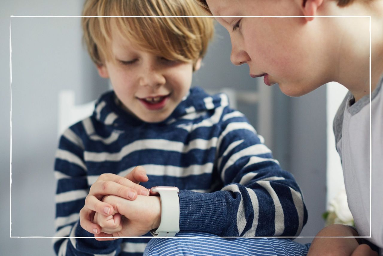 two boys looking at a wristwatch together as part of our best kids&#039; watches round up