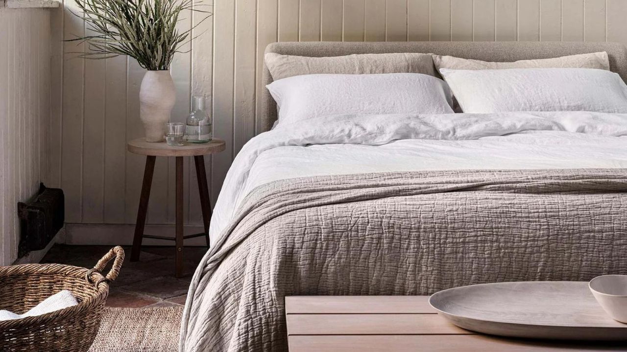 Naturalmat Organic Linen Bed Linen Set on a bed against cream walls.