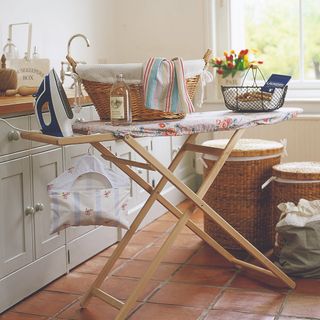 A laundry room with an ironing board and steam iron