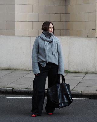 @annacascarina wearing grey cashmere jumpers and black trousers