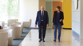 Drew Weissman and Katalin Kariko pictured walking side by side down a hallway