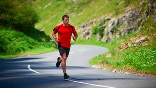 Man running on road through mountains