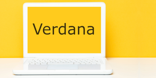 Verdana font seen on yellow laptop screen against yellow wall