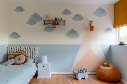 A kids bedroom with a blue painted mural