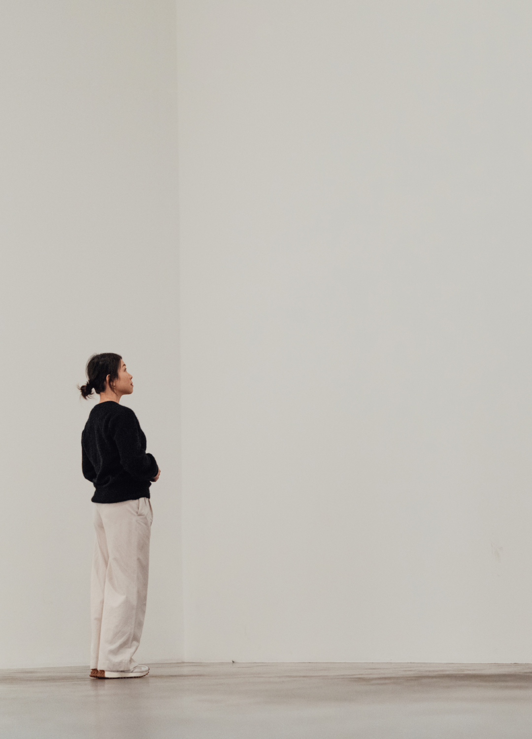Woman looking at a blank white wall