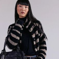 model wears FP and a black shirt, striped cardigan and jeans.