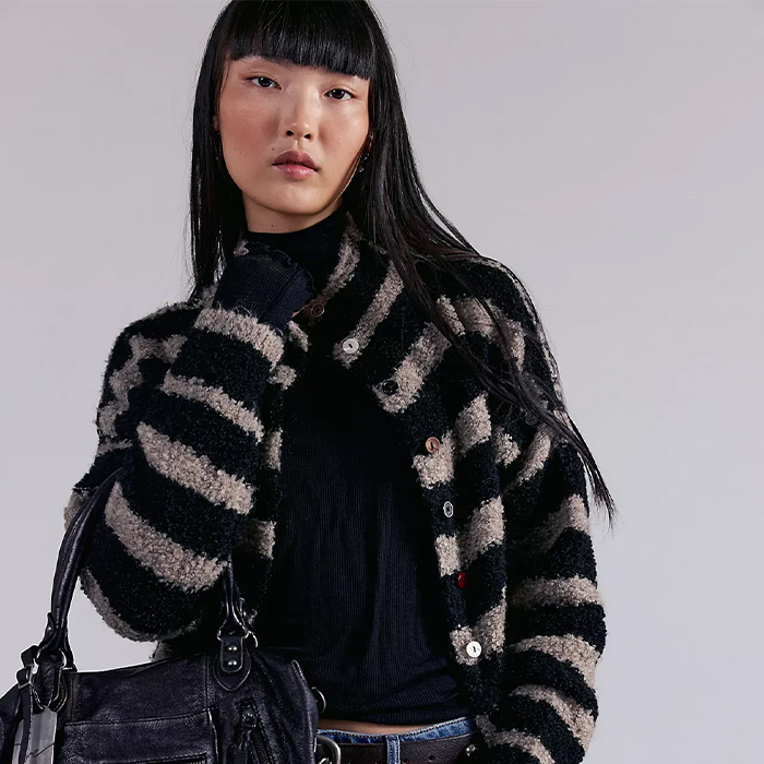 model wears FP and a black shirt, striped cardigan and jeans.
