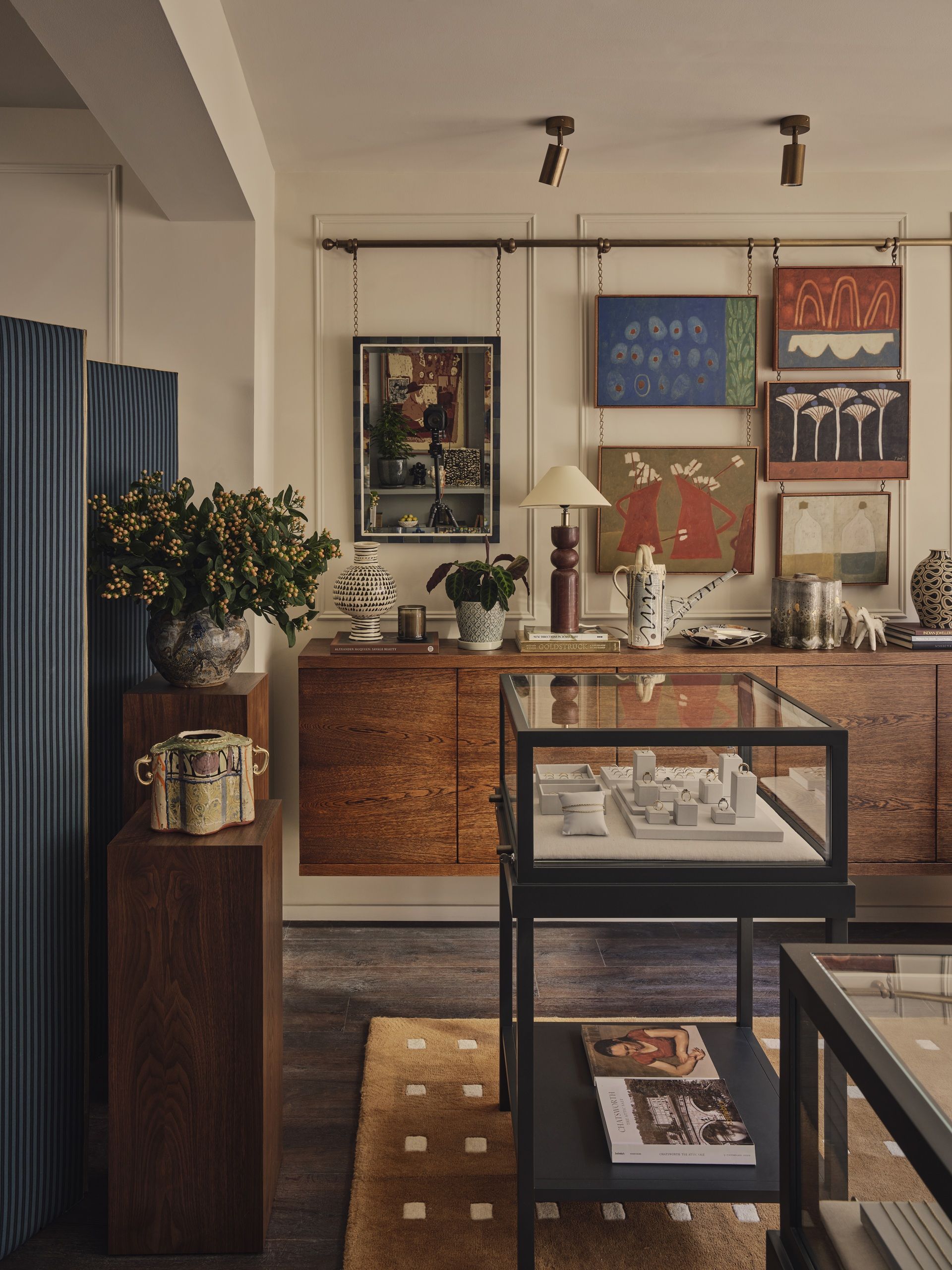 a jewelry shop with layered decor, and wall art hanging from a rail