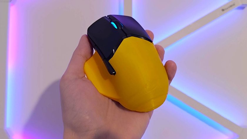Hand holding HyperX Pulsefire Saga Pro mouse yellow shell in front.