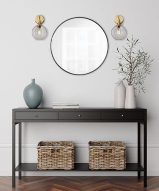 A gray entryway with a black console table and mirror