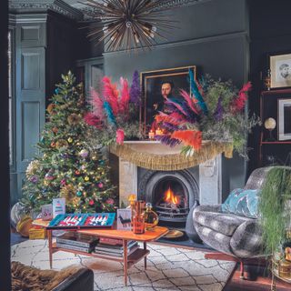 Living room with christmas tree, mantlepiece and bright pink decorations.
