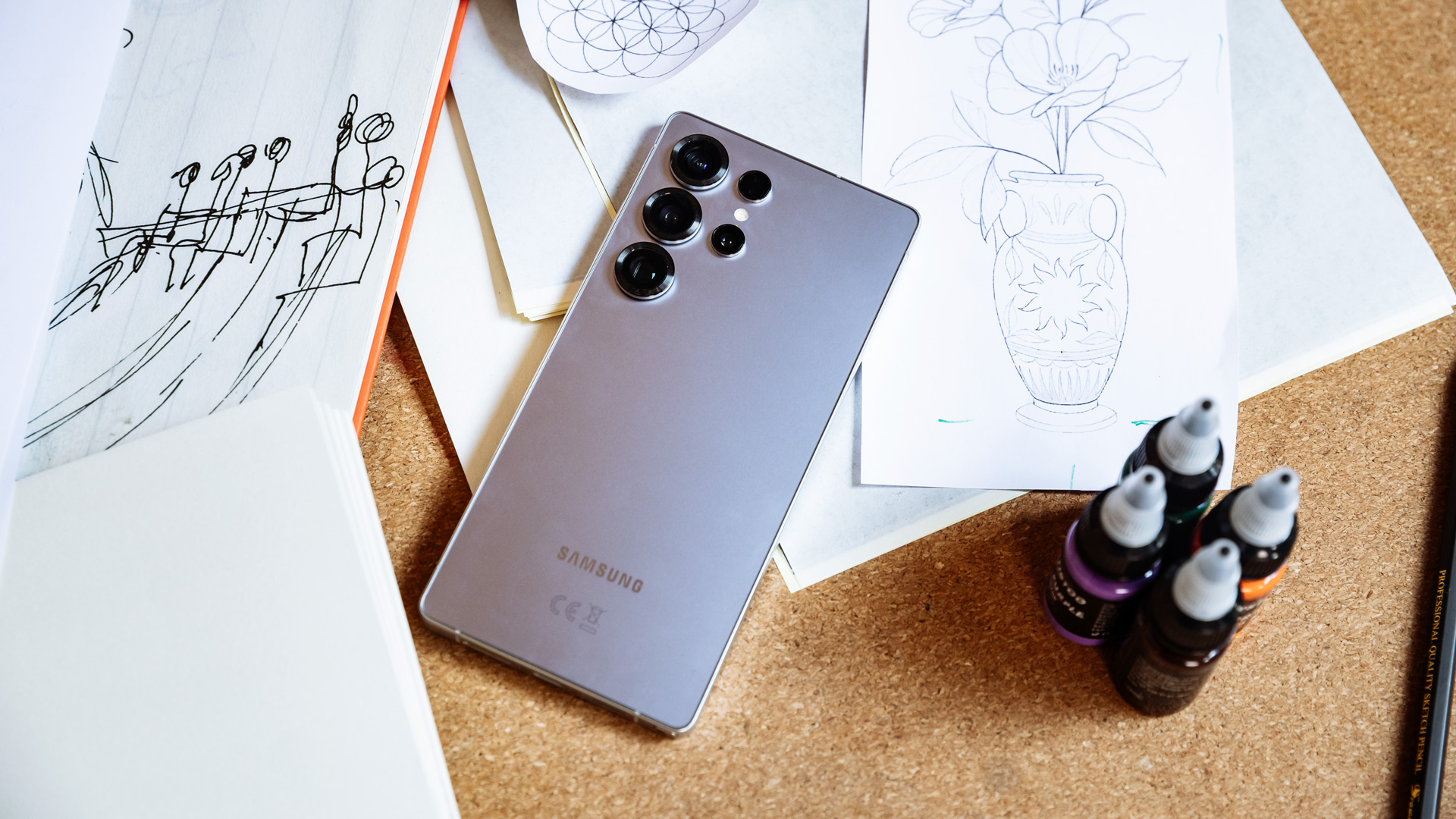 Samsung Galaxy S25 Ultra on a table amongst drawings on paper.