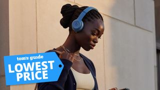 A young woman wearing a pair of Beats Solo 4 headphones and looking at her phone