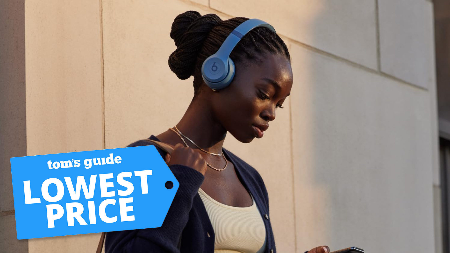 A young woman wearing a pair of Beats Solo 4 headphones and looking at her phone