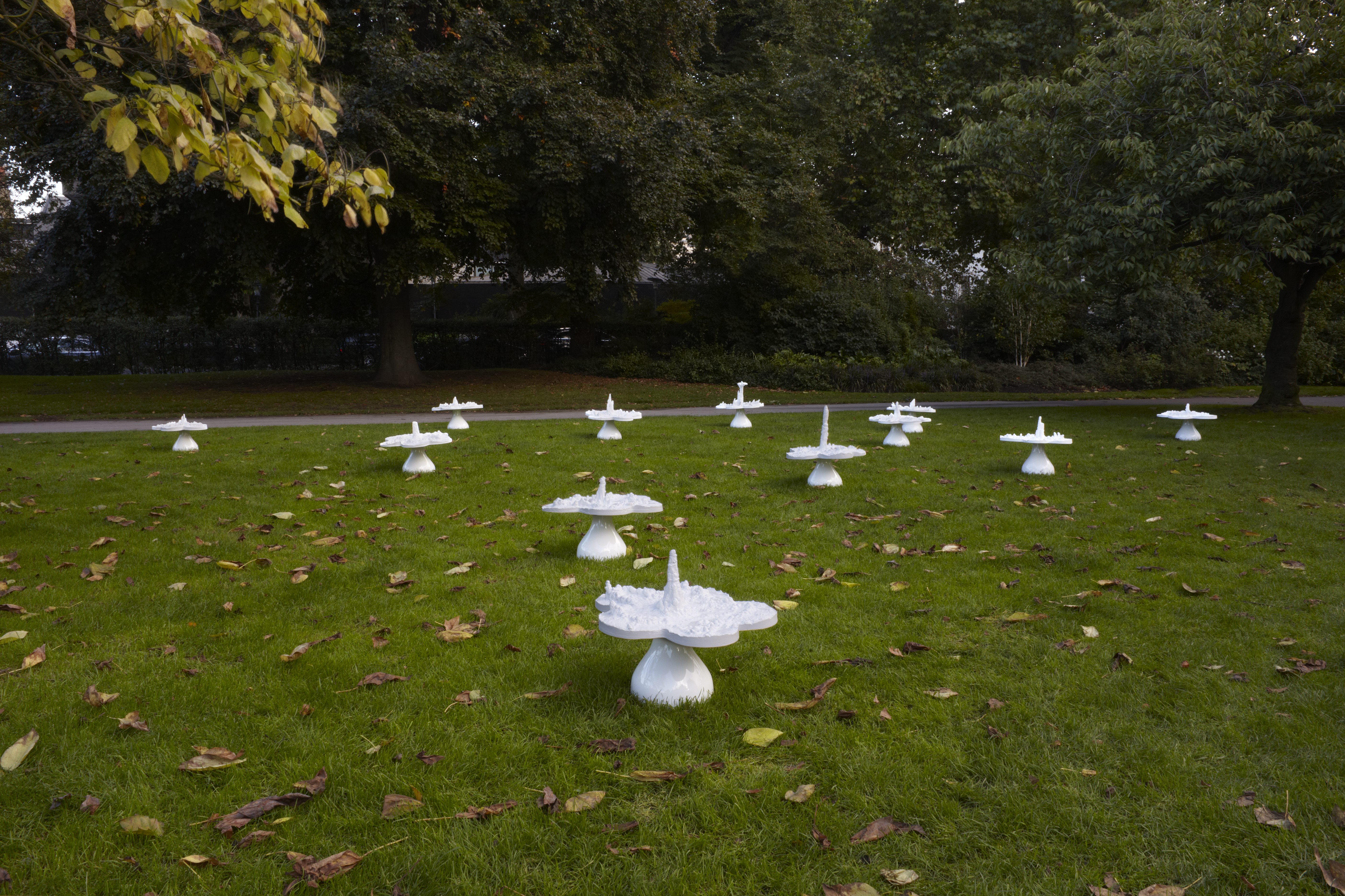 white sculptures set across grass