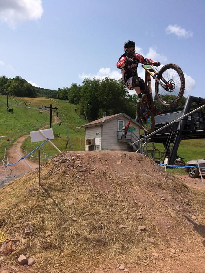 A rider gets air on the downhill course. At this point the downhill and cross country courses are right next to each other.