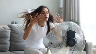 woman using electric fan to cool down