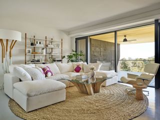 living room with white corner sofa and round jute rug