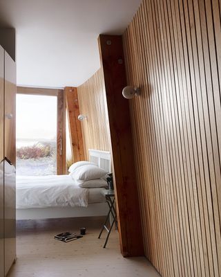 The master suite extends along the length of the house and the timber-lined walls evoke boat interiors