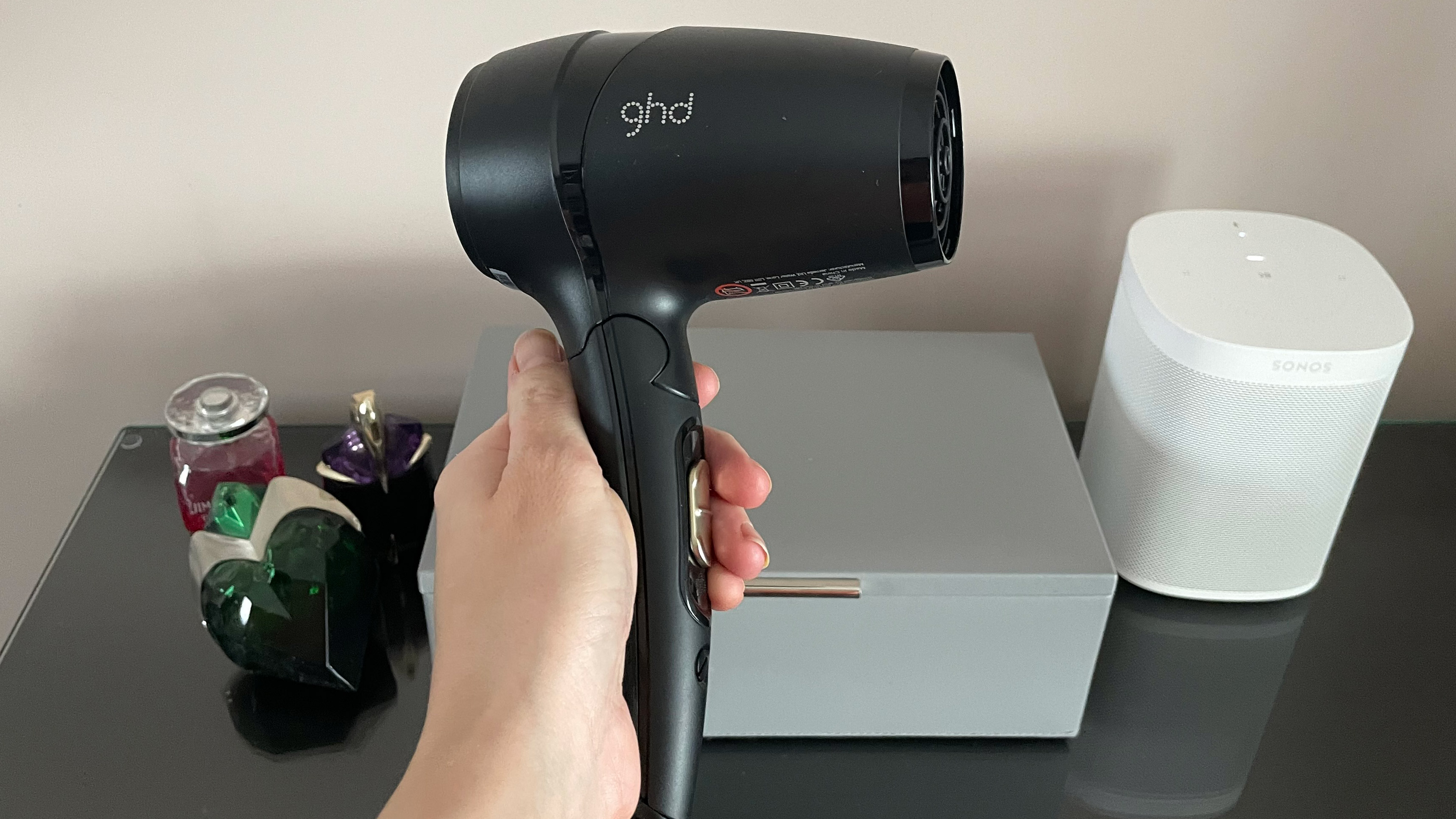 The GHD Flight hair dryer being held in a hand