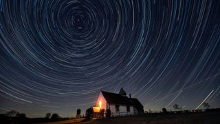 Startrails can be seen moving around the north star above an English country landscape