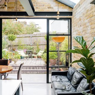 kitchen extension with brick wall glass door garden deck view and sofa