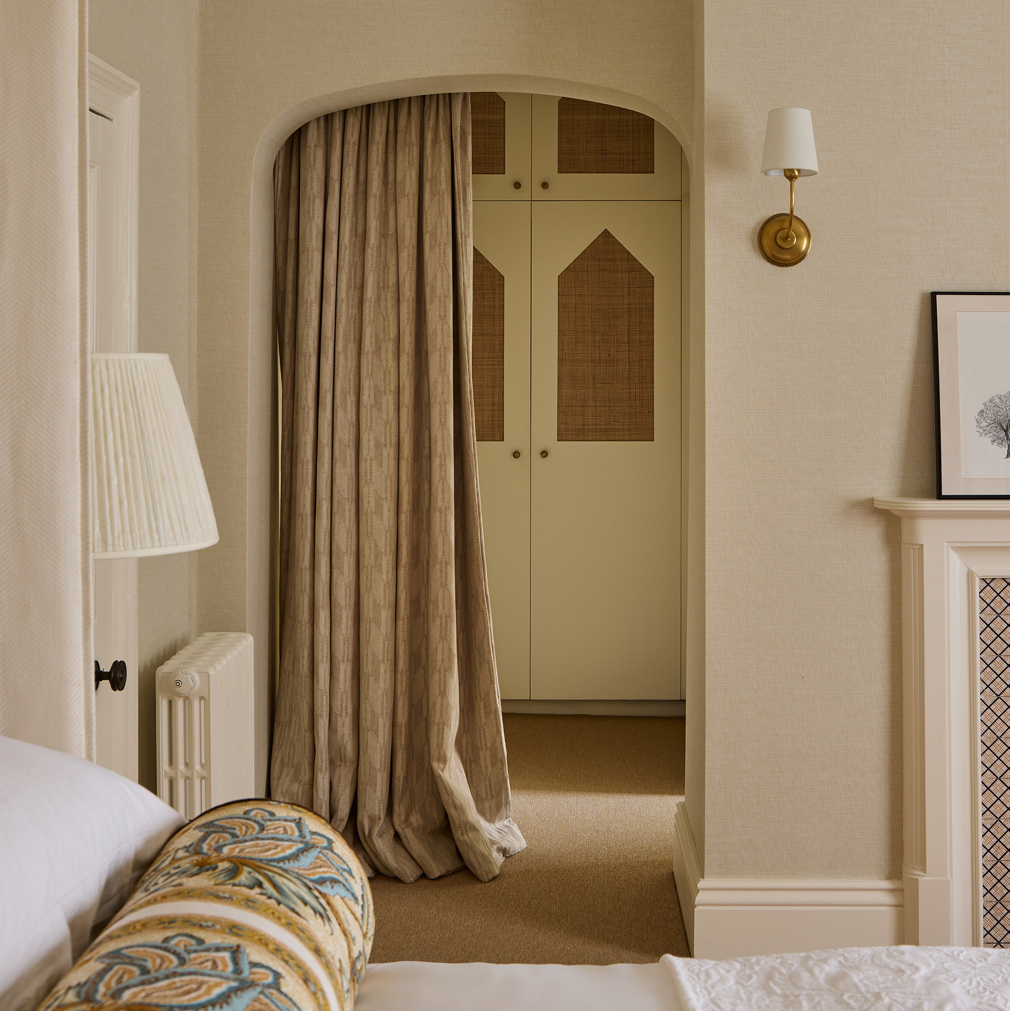 cream bedroom with curtain leading into an ensuite and dressing room