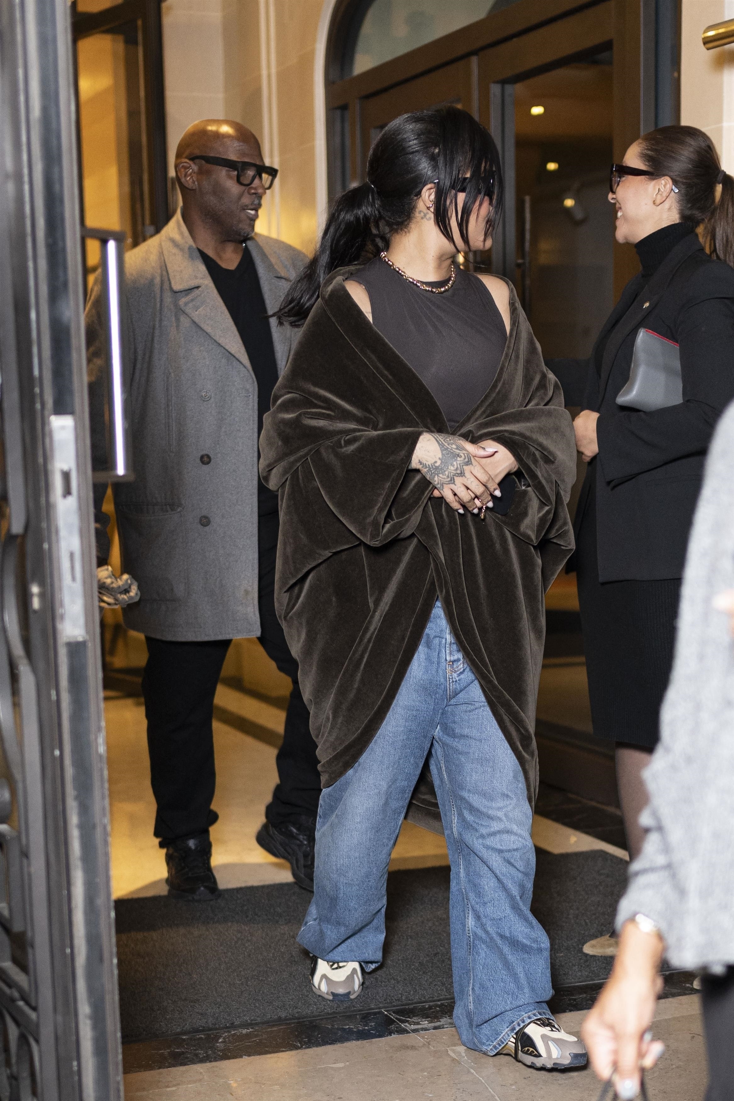 Rihanna was spotted in baggy jeans, statement sneakers, and a shawl, creating her latest high-low look