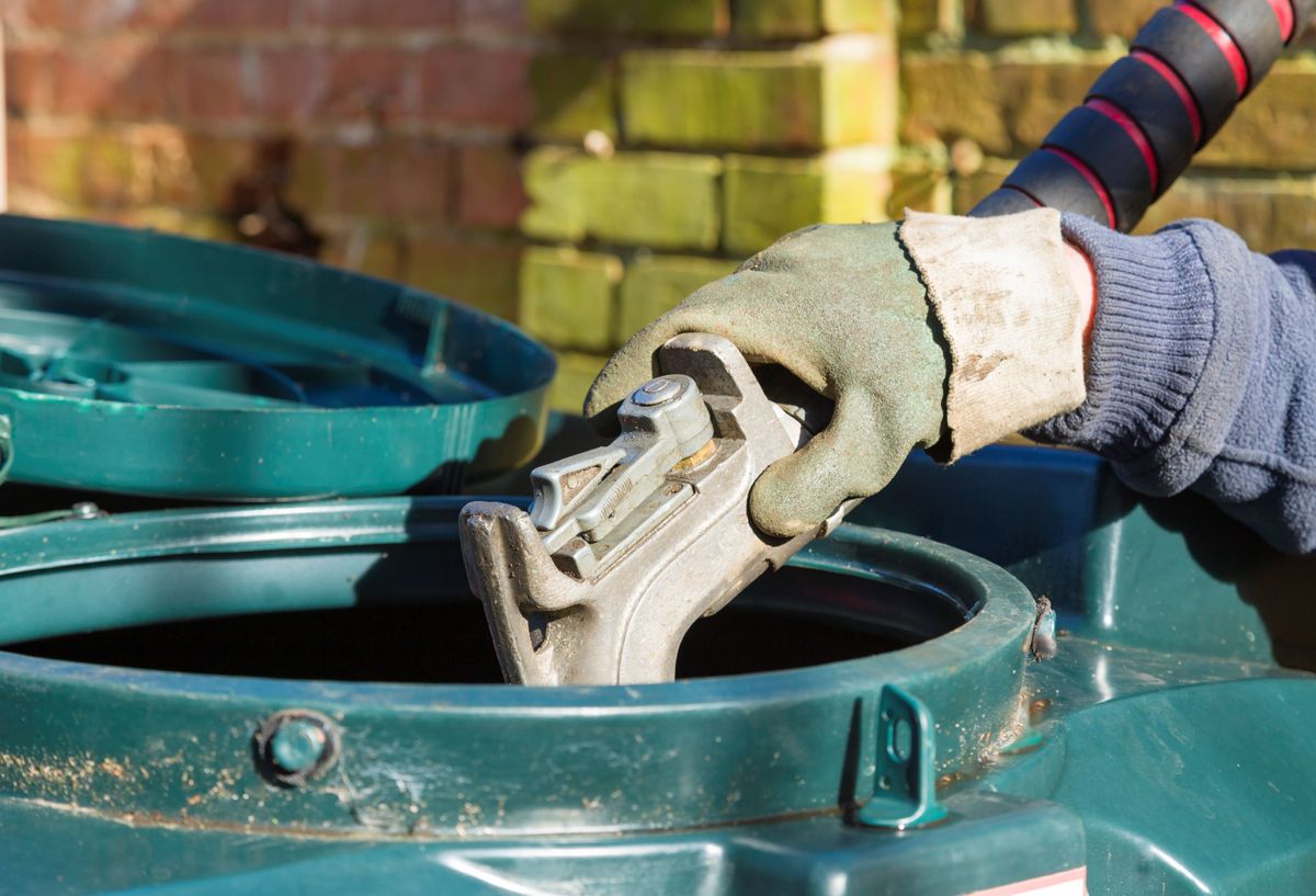 A man filling a domestic oil tank up with heating oil