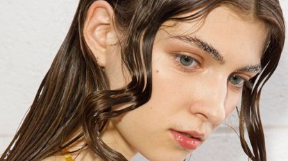  A model poses in the backstage at the Federico Cina fashion show during the Milan Fashion Week S/S with wet-look hair