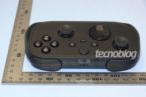 Black prototype Xbox cloud gaming controller with compact design and touchpad-like D-pad beside measuring rulers