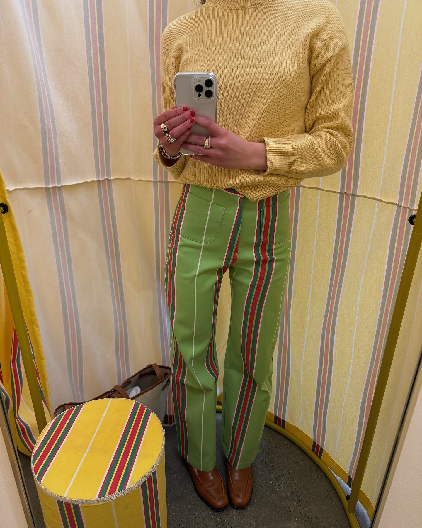 Influencer Lauren wears green striped pants and yellow sweater.