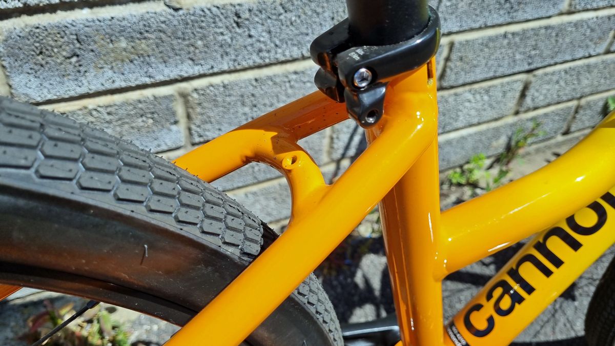 Close up of a mudguard mount on the bridge of two orange seat stays