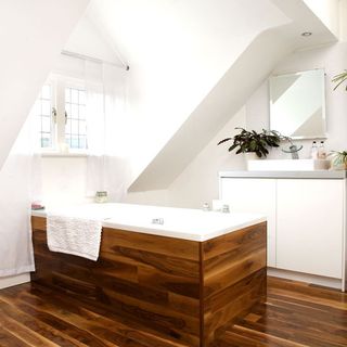bathroom with white walls and pine bath and floor