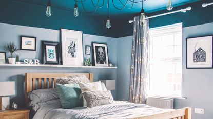 A bedroom with a contrasting blue painted ceiling