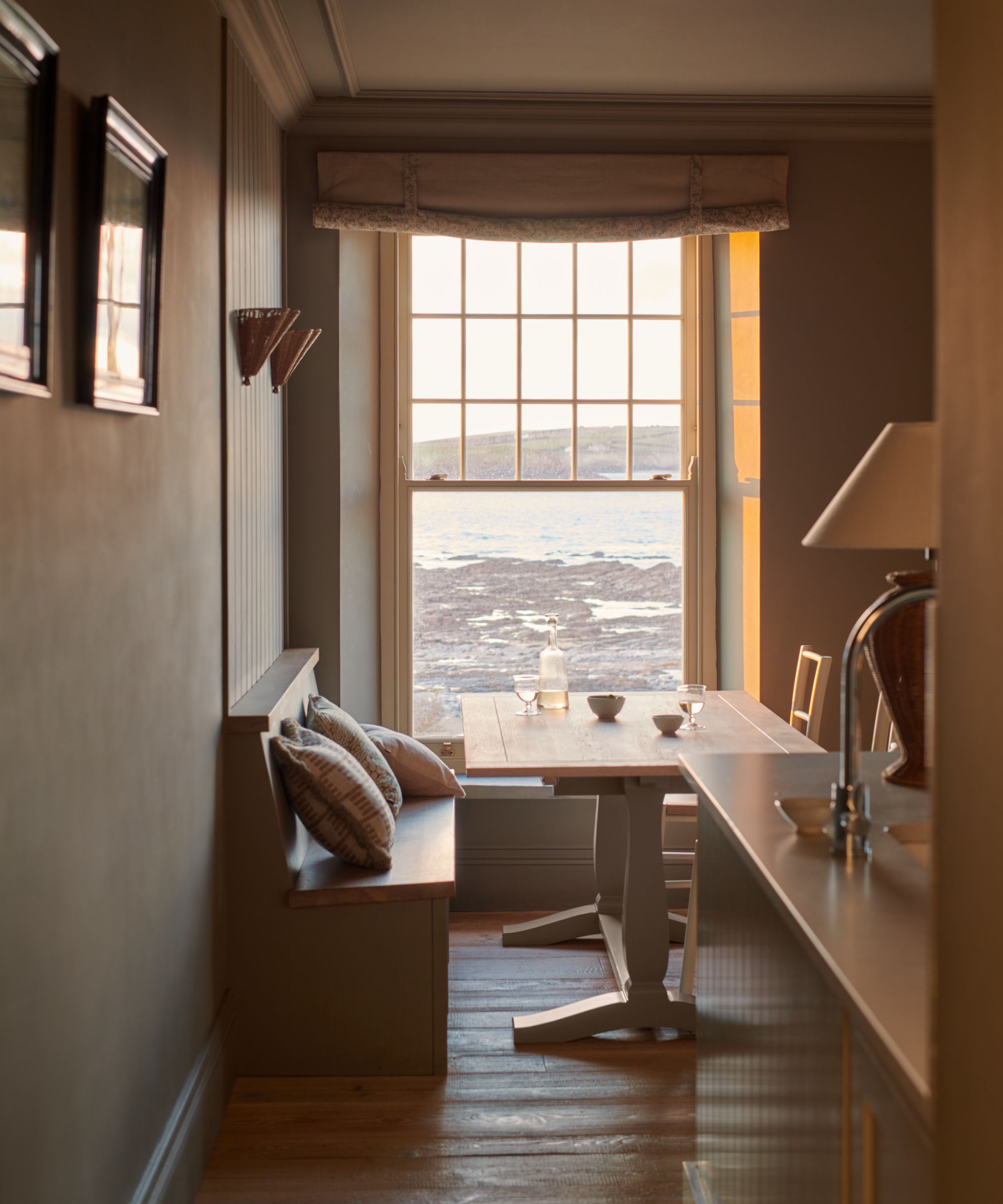 A coastal kitchen with a banquette eat-in area at the end by the window