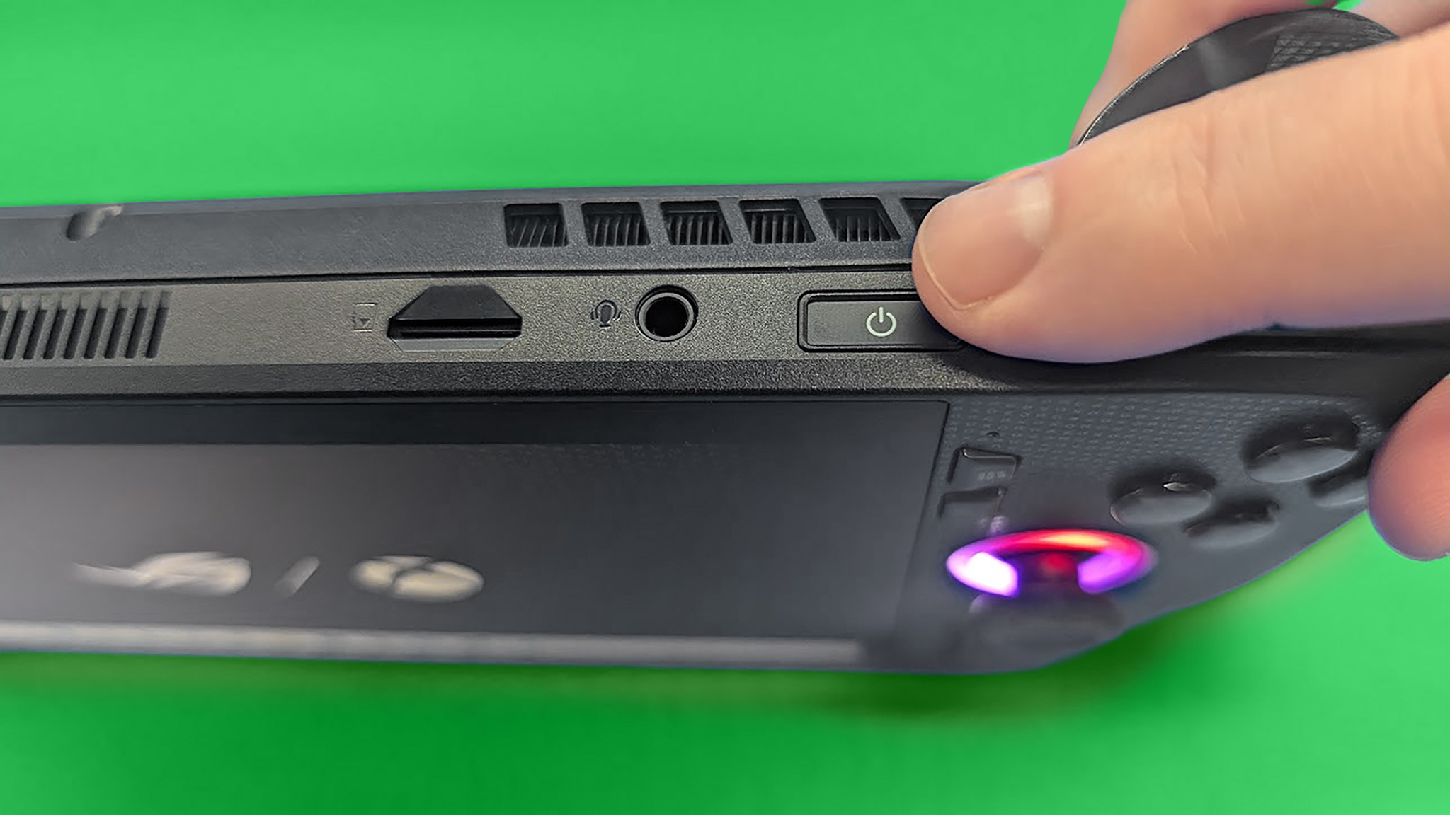 A finger hovering over the ROG Xbox Ally X's fingerprint reader.