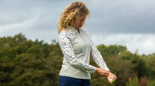 A golfer poses in the Pure Golf Maple Long Sleeve Zip Top