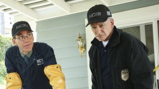 Gibbs and Jimmy (wearing long yellow gloves) looking down at a hot tub at a crime scene in NCIS