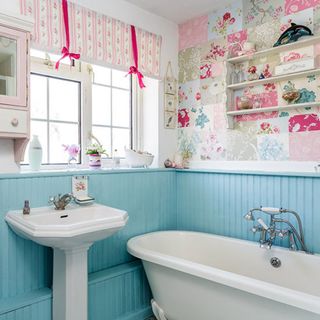 bathroom with blue and floral wall bathtub window and wash basin