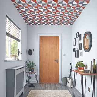 white hallway with metallic ceiling wallpaper and walled pictures