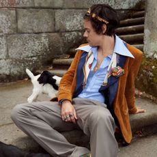 Sitting, Companion dog, Fashion, Street fashion, Human, Canidae, Formal wear, Suit, Outerwear, Jeans, 