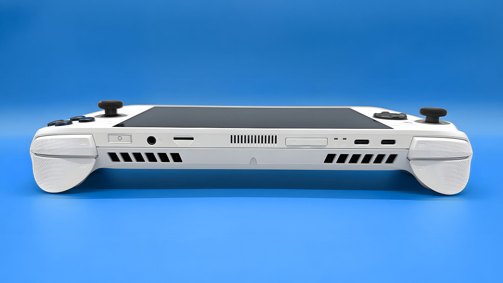 The Xbox Ally lying down with the USB-C ports, volume buttons, microSD card reader, headphone jack, and power button/fingerprint reader visible.