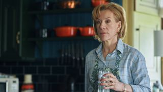 Juliet Stevenson in a shirt and apron holding a glass as Matilda Anchor-Ferrers in Wolf.